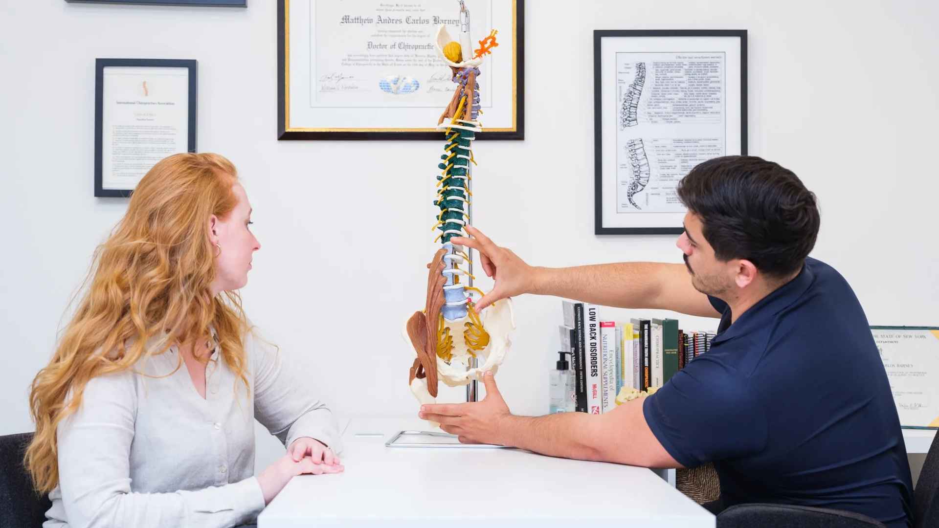 Chiropractor legt wervelkolomgezondheid uit aan patient met anatomisch model tijdens consult in Culemborg