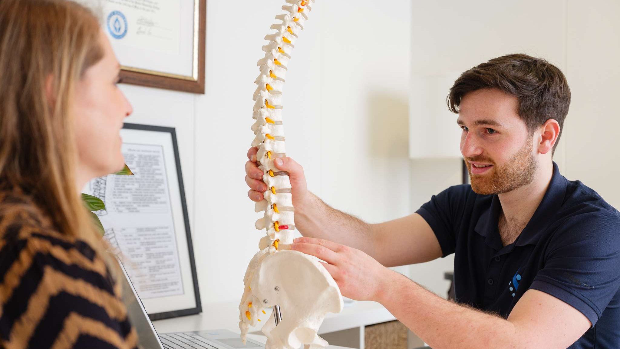 Chiropractor Ben Arctander bespreekt de wervelkolom met een patient in Tiel